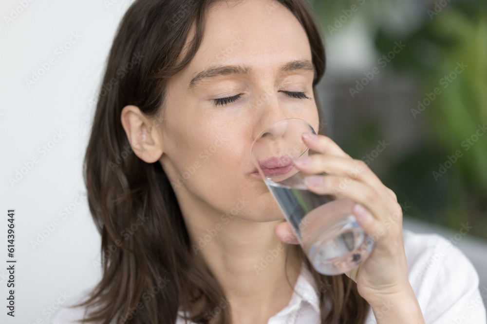 Young woman swallows pill with water, close up. 30s female holds glass reducing thirst with naturel or mineral aqua, prevent body, organism dehydration with fresh clean beverage. Healthy lifestyle Young woman swallows pill with water, close up. 30s female holds glass reducing thirst with naturel or mineral aqua, prevent body, organism dehydration with fresh clean beverage. Healthy lifestyle