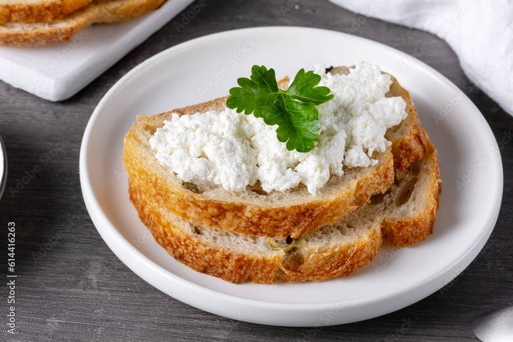 Sandwiches with cottage cheese and bread with olives on a gray table