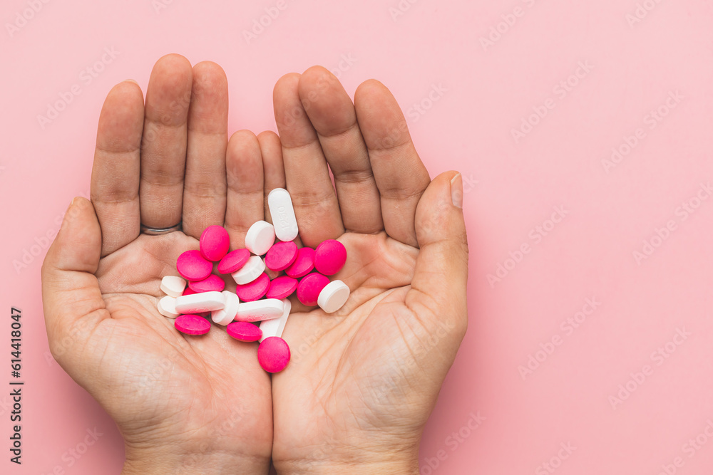 Hand holding medicine pills on pink background for medical and healthcare concept. Hand holding medicine pills on pink background for medical and healthcare concept.