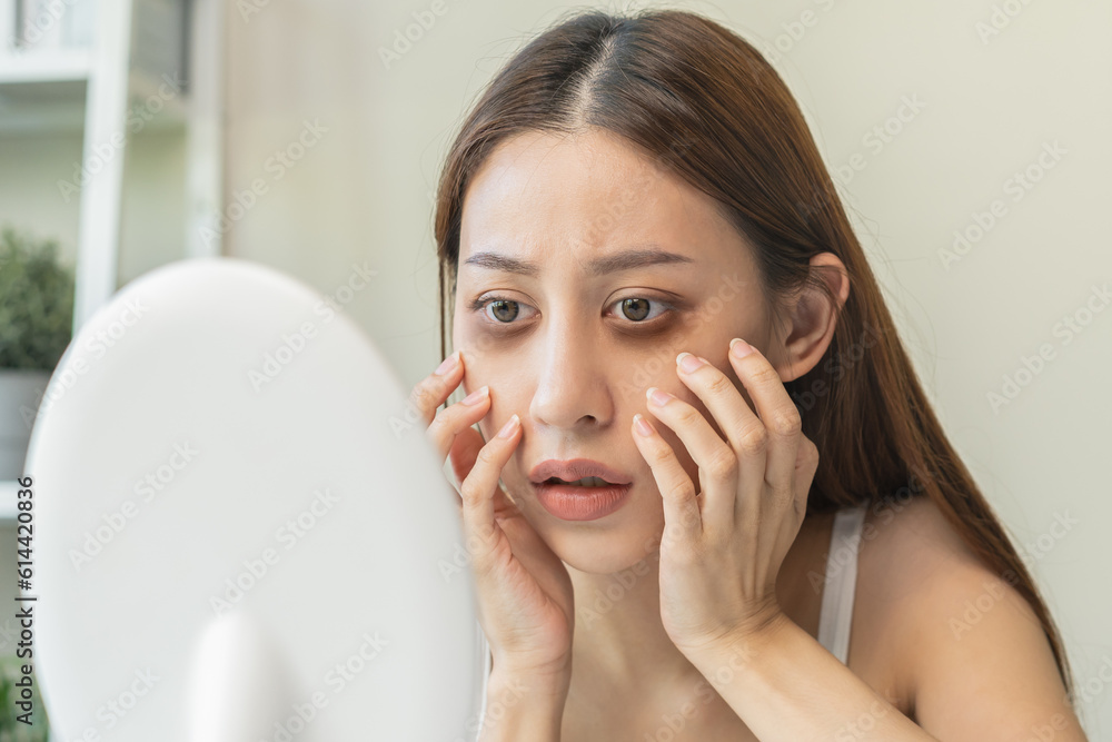 Bored, insomnia asian young woman, girl looking at mirror hand touching under eyes with problem of black circles or panda puffy, swollen and wrinkle on face. Sleepless, sleepy healthcare person. Bored, insomnia asian young woman, girl looking at mirror hand touching under eyes with problem of black circles or panda puffy, swollen and wrinkle on face. Sleepless, sleepy healthcare person.