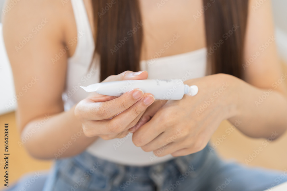 Healthy skin care, asian young woman squeeze out cream on her back hand before putting moisturizer for treatment ,applying on her face, makeup routine in the morning at home. Facial Beauty. Healthy skin care, asian young woman squeeze out cream on her back hand before putting moisturizer for treatment ,applying on her face, makeup routine in the morning at home. Facial Beauty.