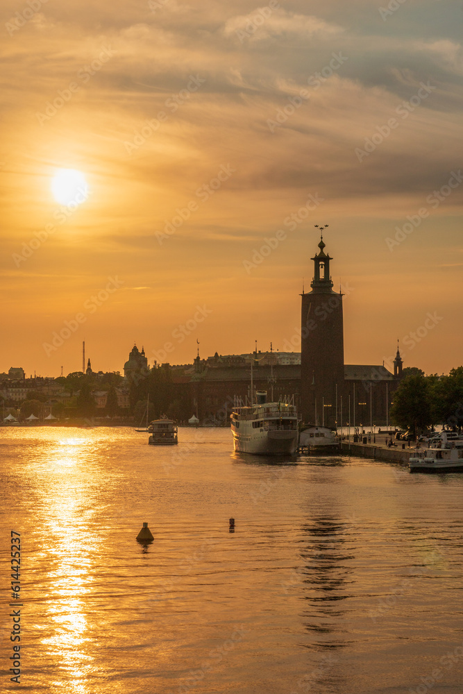 Stockholm Town Hall at sunset with boats in the foreground, Sweden.