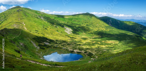 Lake Nesamovyte in Ukraine. Rhododendron flowers in the Carpathians. Mountain lake.