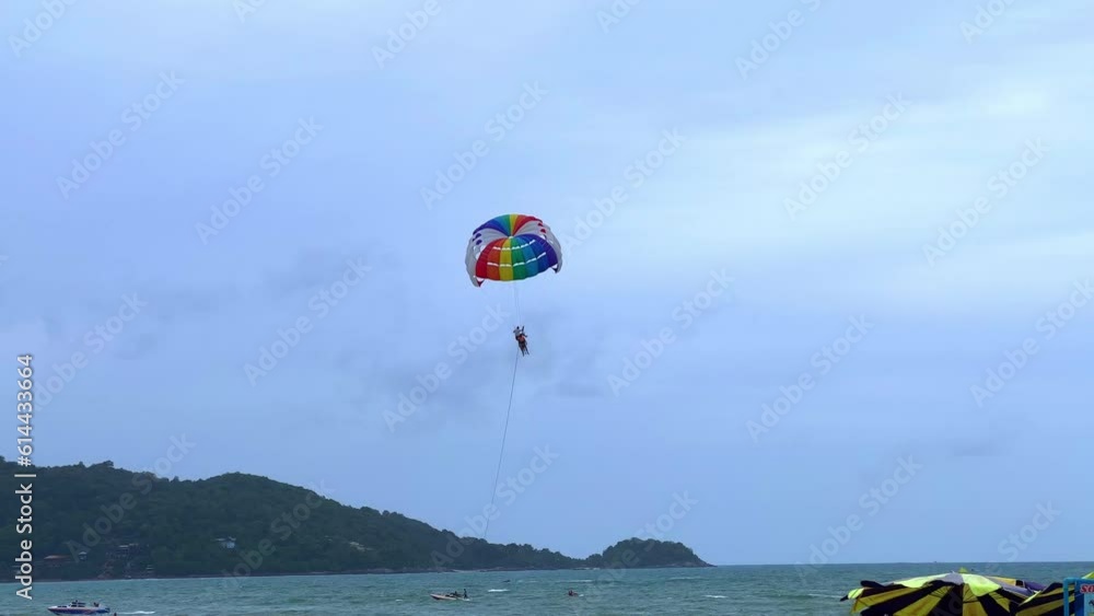 Parasailing on a windy day at Patong Beach phuket thailand. Speed boats and jet sky’s roaming Parasailing on a windy day at Patong Beach phuket thailand. Speed boats and jet sky’s roaming