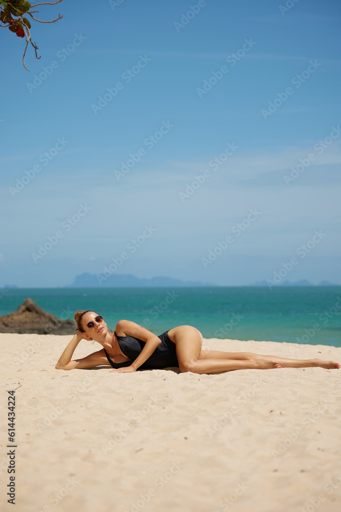 fashion outdoor photo of beautiful sexy woman with blond hair in elegant swimming suit relaxing on summer beach