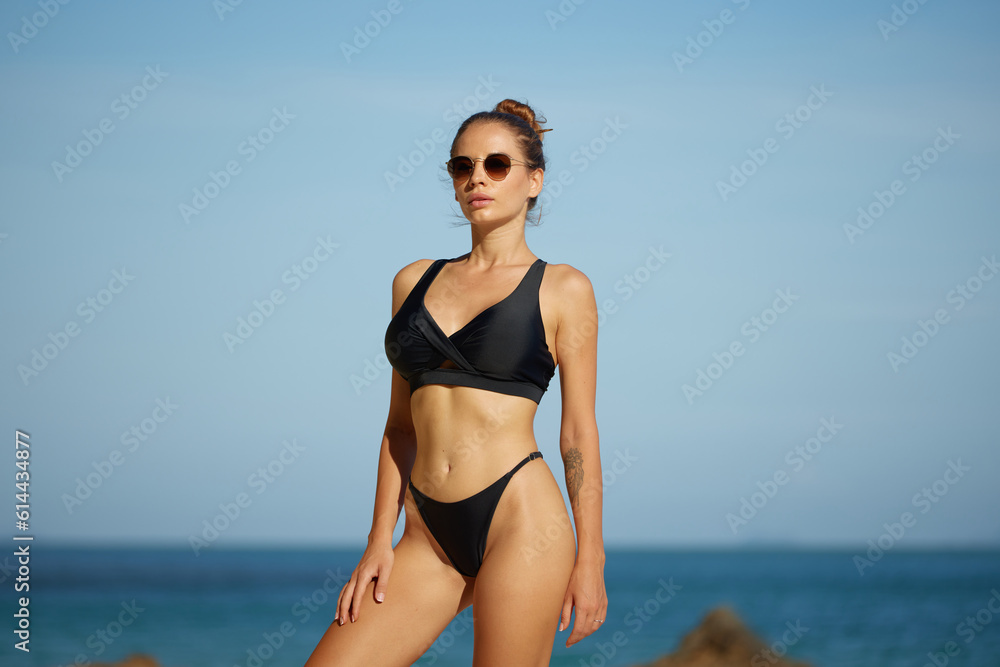 Beautiful girl in bikini on the beach. Young woman in bikini on the beach. Summer vocation concept