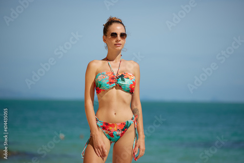 Beautiful girl in bikini on the beach. Young woman in bikini on the beach. Summer vocation concept