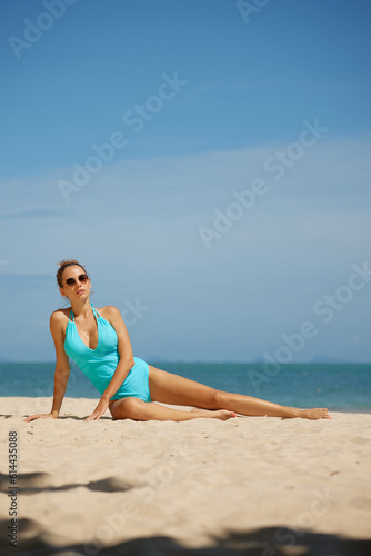 Young beautiful red hair woman in body swimsuit posing on tropical sandy beach. Summer vacation concept