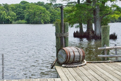 Beautiful waterfront scene of a wooden barrel and a boat pier in Edenton North Carolina