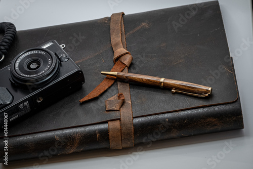 pen, camera, and leather book photo