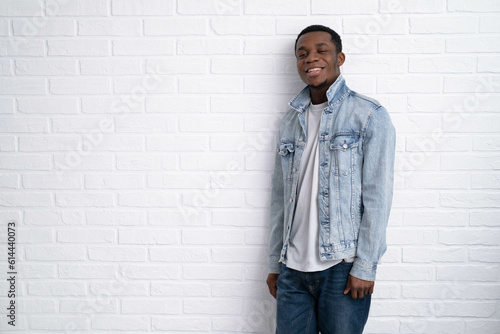 Portrait young handsome african black man wearing denim jeans jacket against brick with wall outdoors with copyspace
