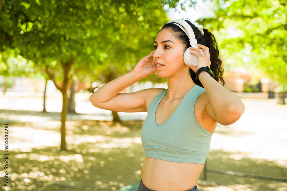 Young woman with headphones preparing to run in the park Young woman with headphones preparing to run in the park