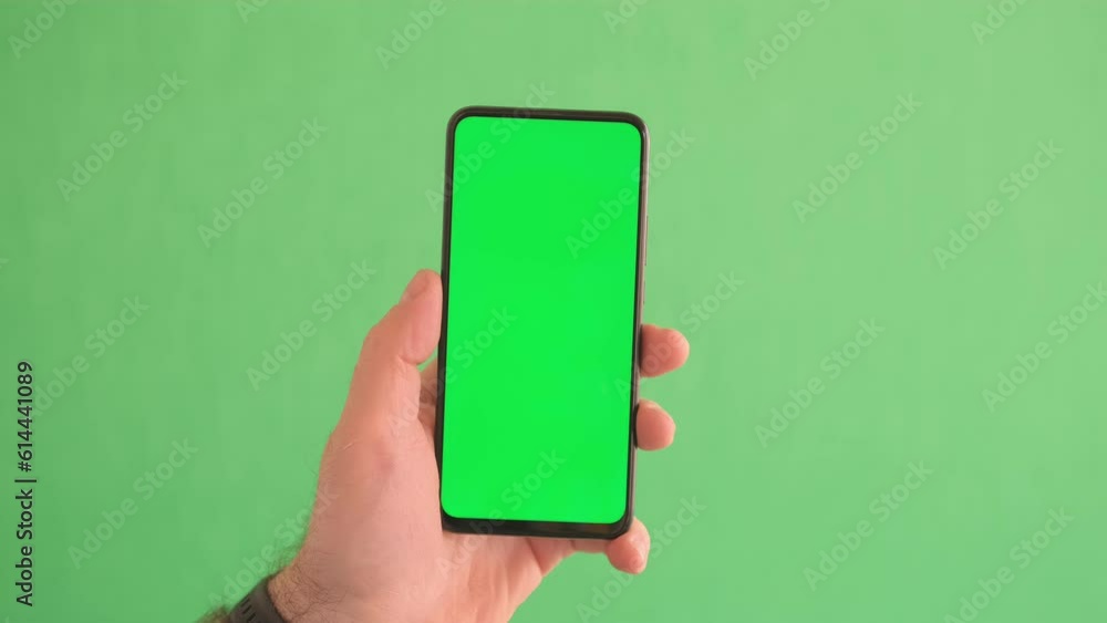 4K Young man hand touch smartphone with green screen on green background 4K Young man hand touch smartphone with green screen on green background