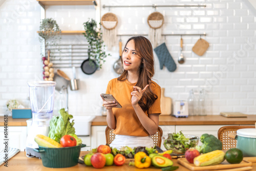Portrait of beauty body slim healthy asian woman having fun cooking and preparing cooking vegan food healthy eat with fresh vegetable salad on counter in kitchen at home.Diet concept.Fitness, healthy