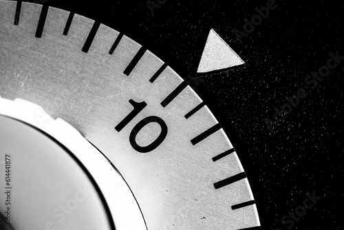 monochrome close-up of an old analog laboratory timer set to ten