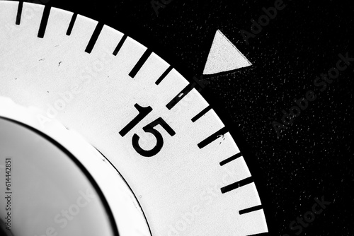 monochrome close-up of an old analog laboratory timer set to 15