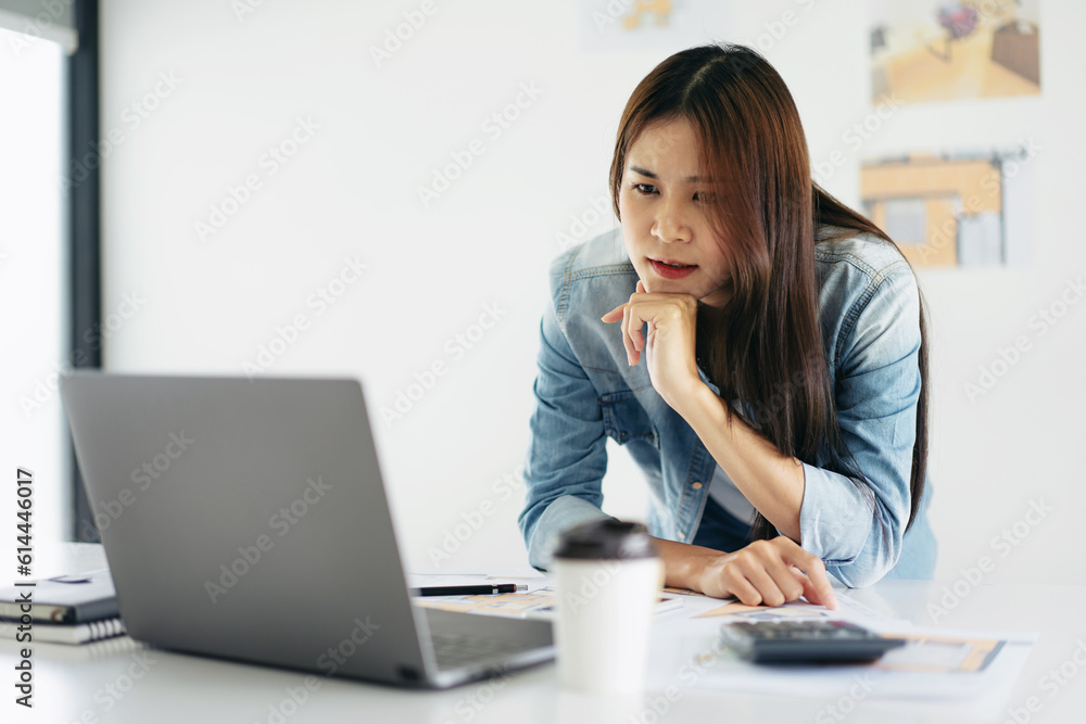 Woman architect reading data on laptop and thinking about new pr Woman architect reading data on laptop and thinking about new pr