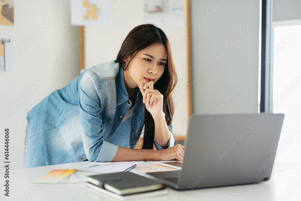 Woman architect reading data on laptop and thinking about new pr Woman architect reading data on laptop and thinking about new pr