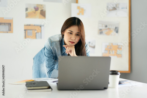 Woman architect reading data on laptop and thinking about new pr