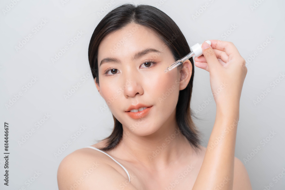 Asian woman is dripping serum on her face.Facial skin care concept. skin care