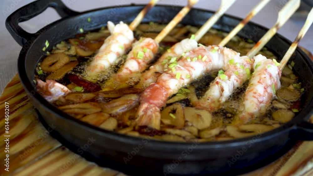 Garlic brochette prawns, in a casserole with boiling oil Garlic brochette prawns, in a casserole with boiling oil