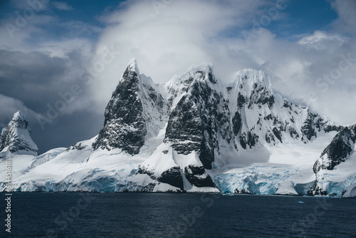 Landscape of snowy mountains and icy shores of the Lemaire Channel in the Antarctic Peninsula, Antarctica. Global warming and climate change concept.