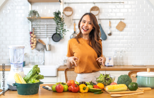 Portrait of beauty body slim healthy asian woman having fun cooking and preparing cooking vegan food healthy eat with fresh vegetable salad on counter in kitchen at home.Diet concept.Fitness, healthy