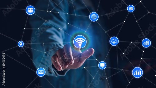 Smart business IOT, internet of things concept. Businessman touching IOT icon on virtual screen, connected internet network to access AI intelligence, business analytics, internet investing.