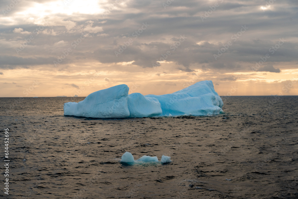 Beautiful iceberg floating in the water. Photo taken at sunset in Antarctica and Arctic Greenland. Global warming and climate change and travel concept. Beautiful iceberg floating in the water. Photo taken at sunset in Antarctica and Arctic Greenland. Global warming and climate change and travel concept.