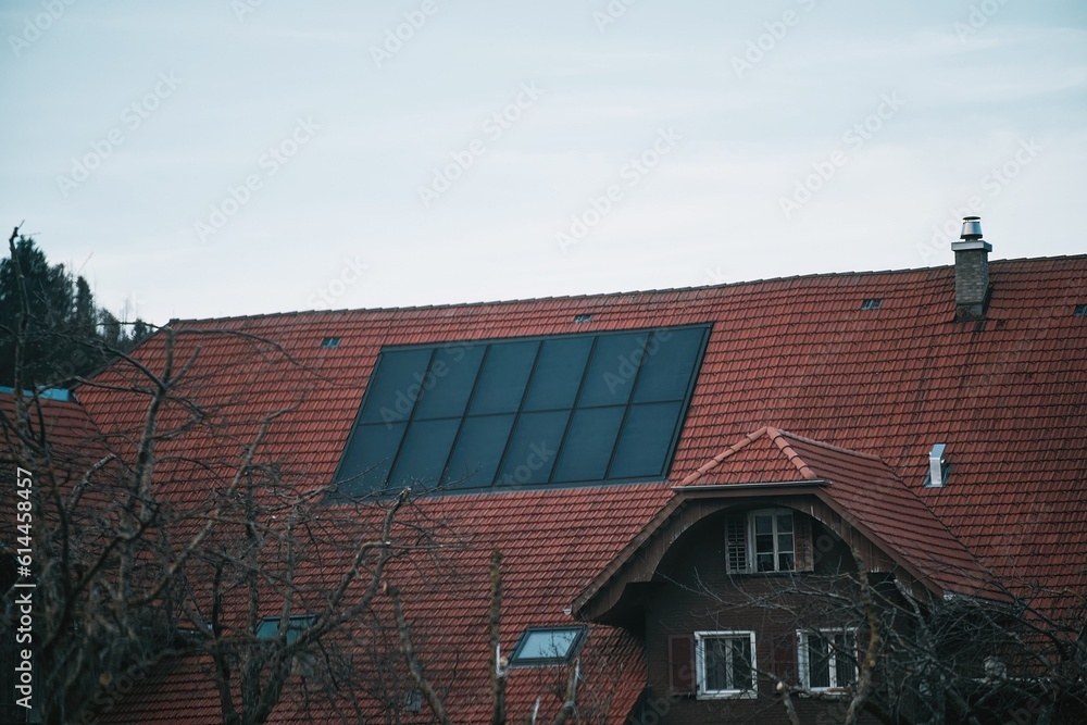 Water solar collector on a red metal roof. Solar thermal and solar panel for hot water.