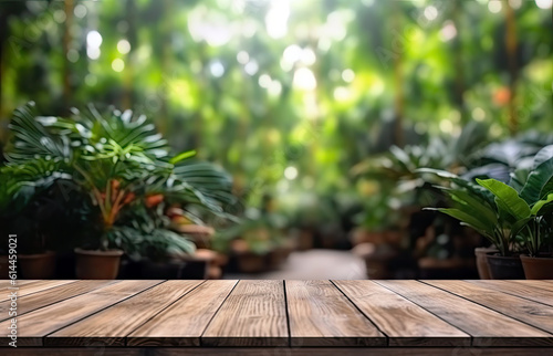 Wooden table top on blur background of green garden with bokeh sunlight. High quality photo