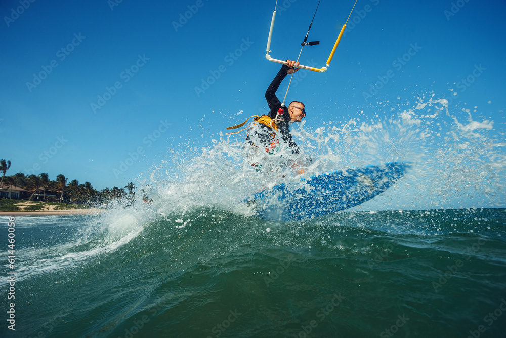 Kite surfer riding a kiteboard on the sea with splash
