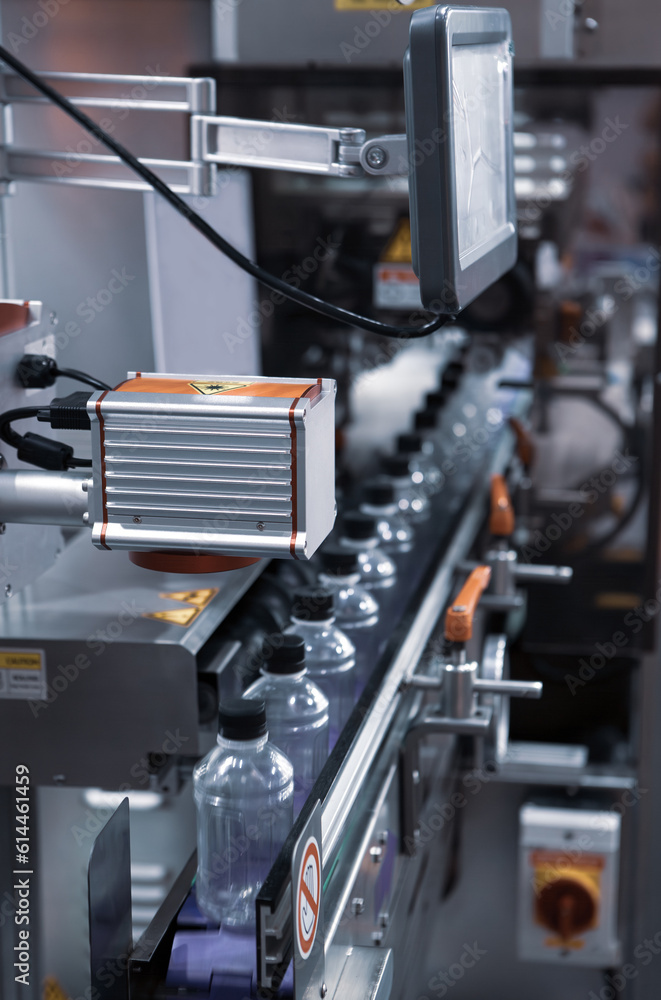 Fototapeta premium Liquid filling and bottle capping machine. Water bottling plant.