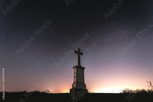 kapliczka murowana z krzyżem w polu na tle nocnego nieba z gwiazdami photo