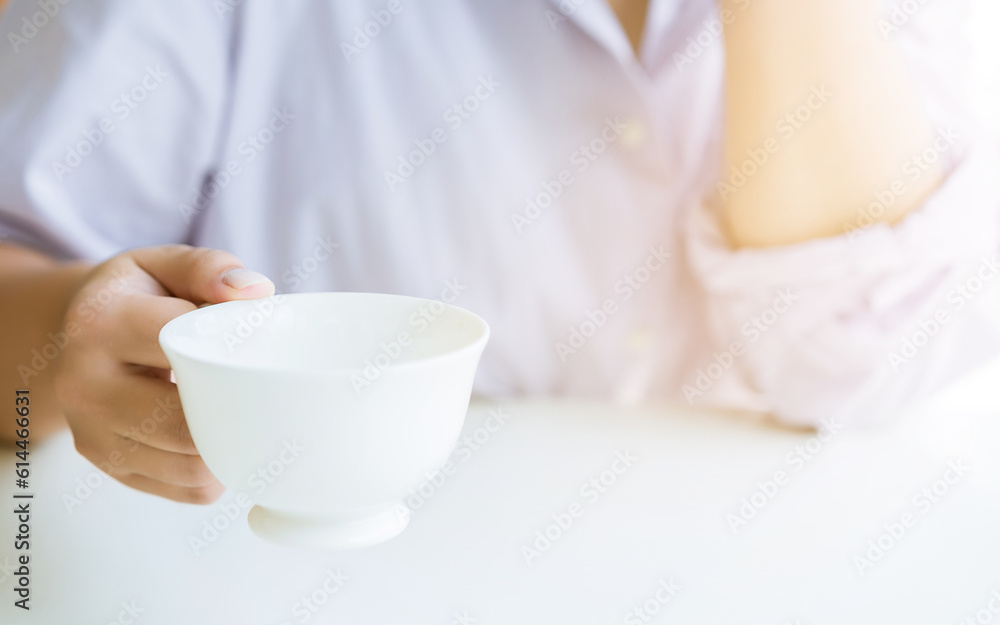Woman's hand holding a cup of coffee Woman's hand holding a cup of coffee