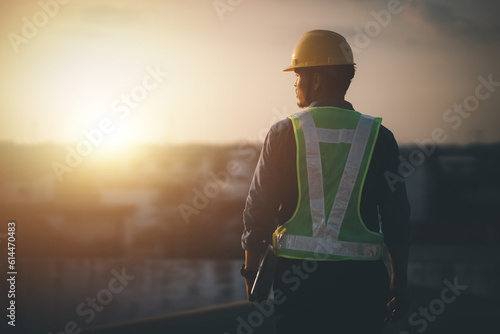Engineer on a construction site at sunset. Working on the roof .