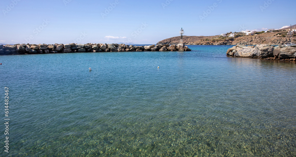 Greece destination Tinos island Agios Romanos village Cyclades. Transparent sea beacon breakwater.
