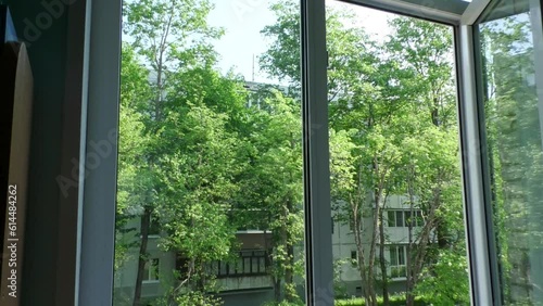 View from an open window from a height on a green landscape courtyard.  Summer mood a look outside at nature and at home.
