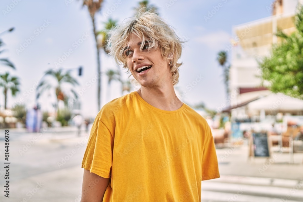Young blond man smiling confident looking to the side at street Young blond man smiling confident looking to the side at street