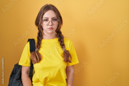 Young caucasian woman wearing student backpack over yellow background skeptic and nervous  frowning upset because of problem. negative person.