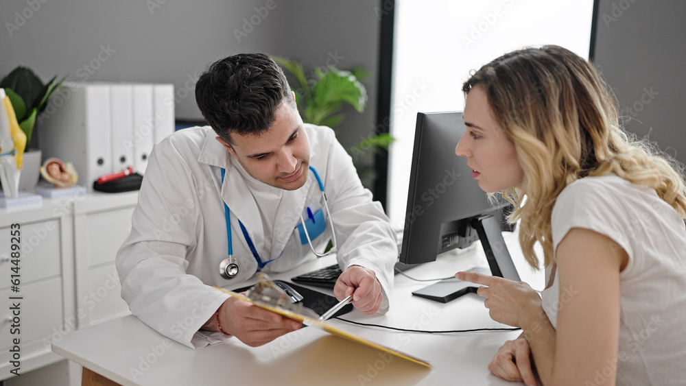Man and woman doctor and patient having consultation showing medical report at clinic Man and woman doctor and patient having consultation showing medical report at clinic