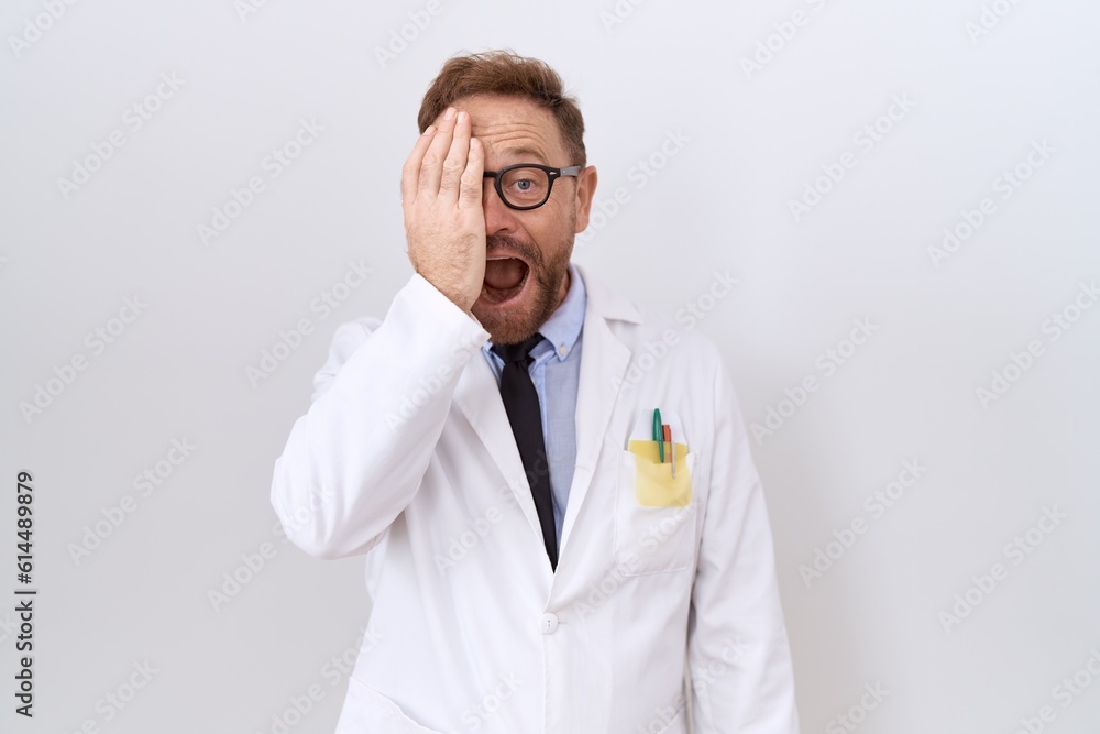 Middle age doctor man with beard wearing white coat covering one eye with hand, confident smile on face and surprise emotion. Middle age doctor man with beard wearing white coat covering one eye with hand, confident smile on face and surprise emotion.