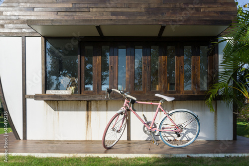 A pink bicycle is parked at the entrance of a cafe with a welcome sign