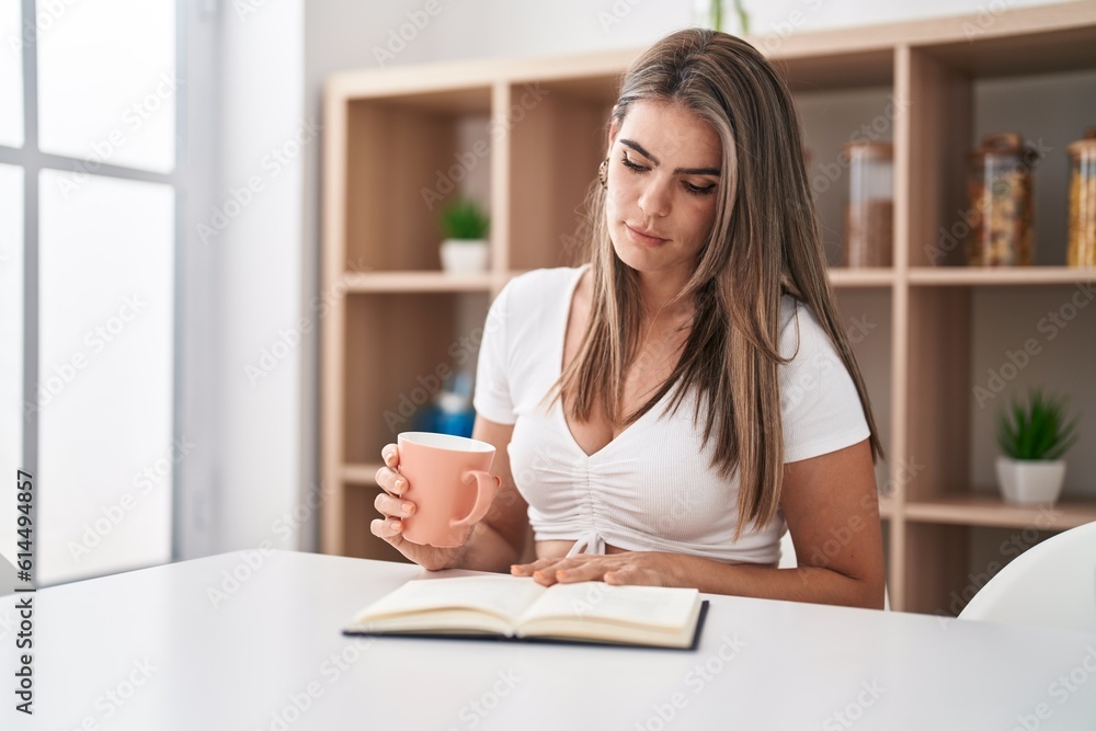 Young woman reading book and drinking coffee at home Young woman reading book and drinking coffee at home