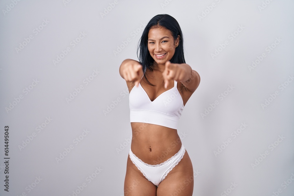 Hispanic woman wearing lingerie pointing to you and the camera with fingers, smiling positive and cheerful Hispanic woman wearing lingerie pointing to you and the camera with fingers, smiling positive and cheerful