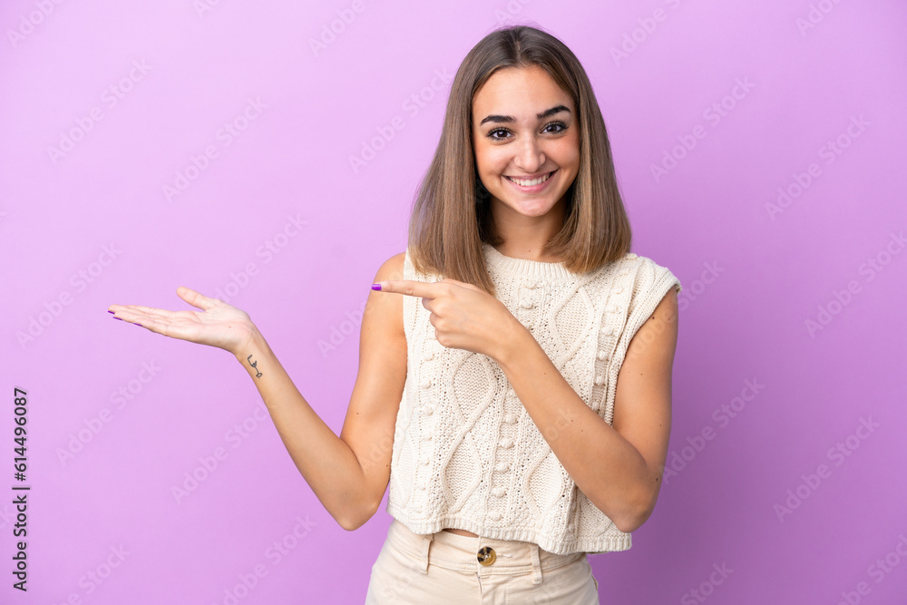 Young caucasian woman isolated on purple background holding copyspace imaginary on the palm to insert an ad Young caucasian woman isolated on purple background holding copyspace imaginary on the palm to insert an ad