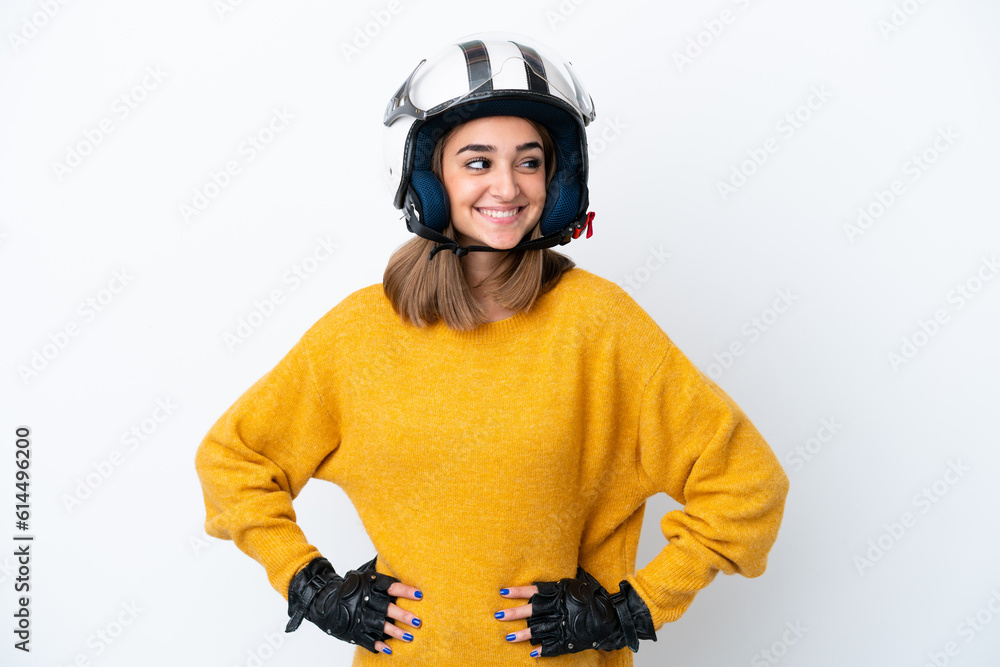 Young caucasian woman with a motorcycle helmet isolated on white background posing with arms at hip and smiling Young caucasian woman with a motorcycle helmet isolated on white background posing with arms at hip and smiling
