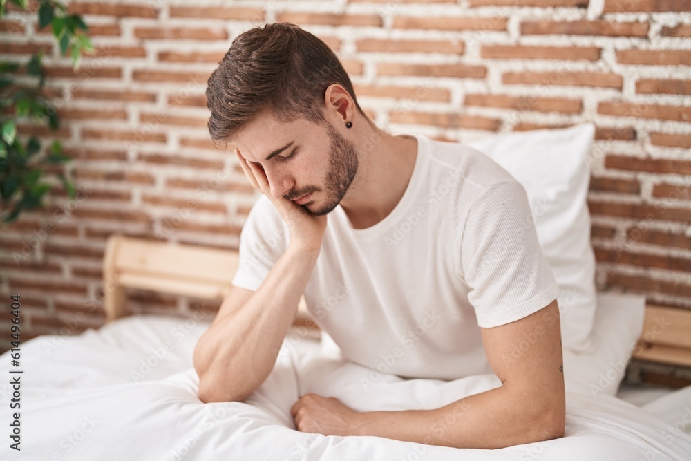 Young caucasian man stressed sitting on bed at bedroom Young caucasian man stressed sitting on bed at bedroom