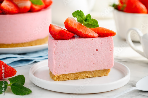 A slice of no bake strawberry cheesecake on a white plate. Close up. Selective focus