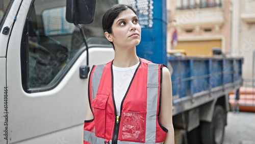 Young beautiful hispanic woman builder standing by truck at street